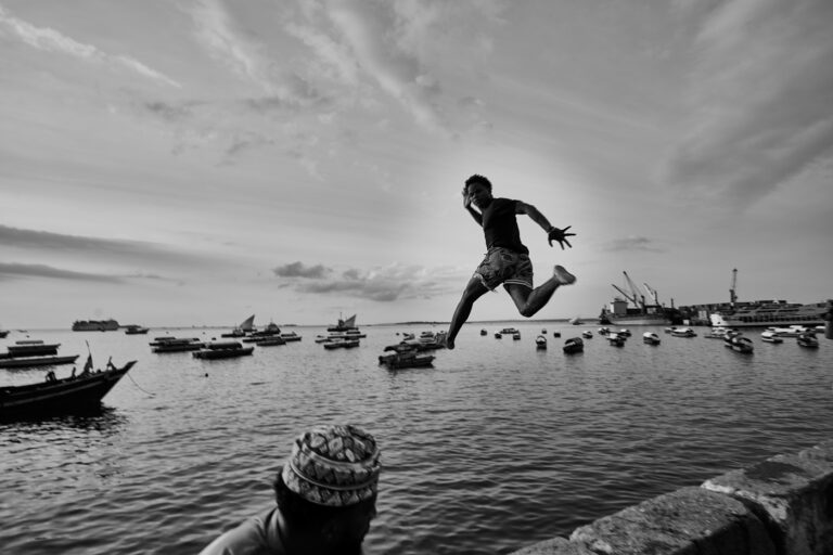 Saut face à la baie de Stonetown à Zanzibar