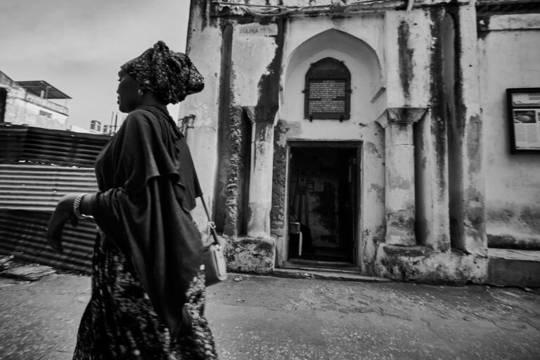 Femme en boubou devant l'ancien Hammam de Stonetown à Zanzibar