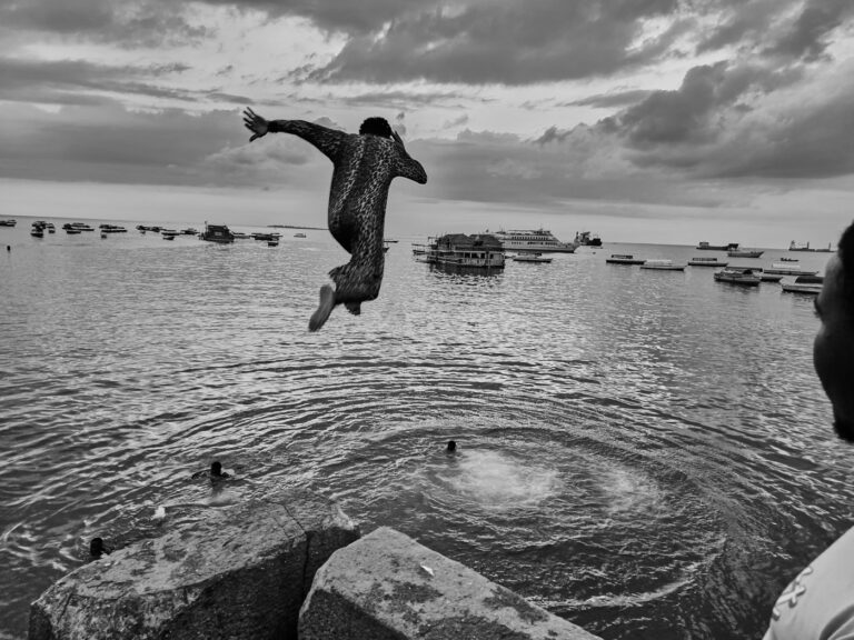Saut en tenue léopard face à la baie de Stonetown à Zanzibar